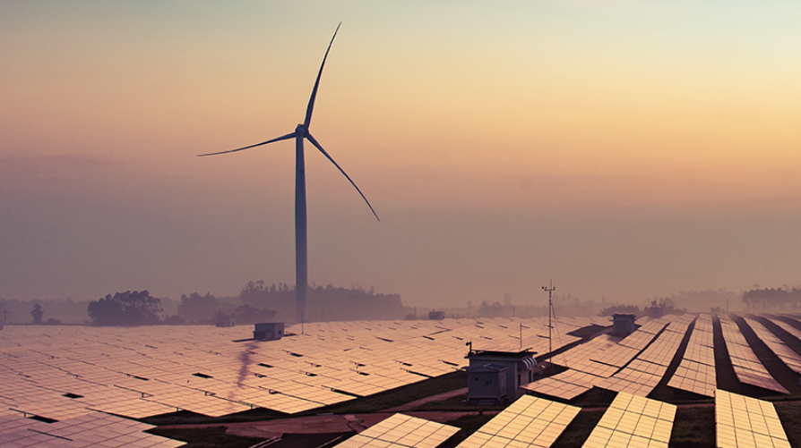 wind turbines and solar panels at sunset