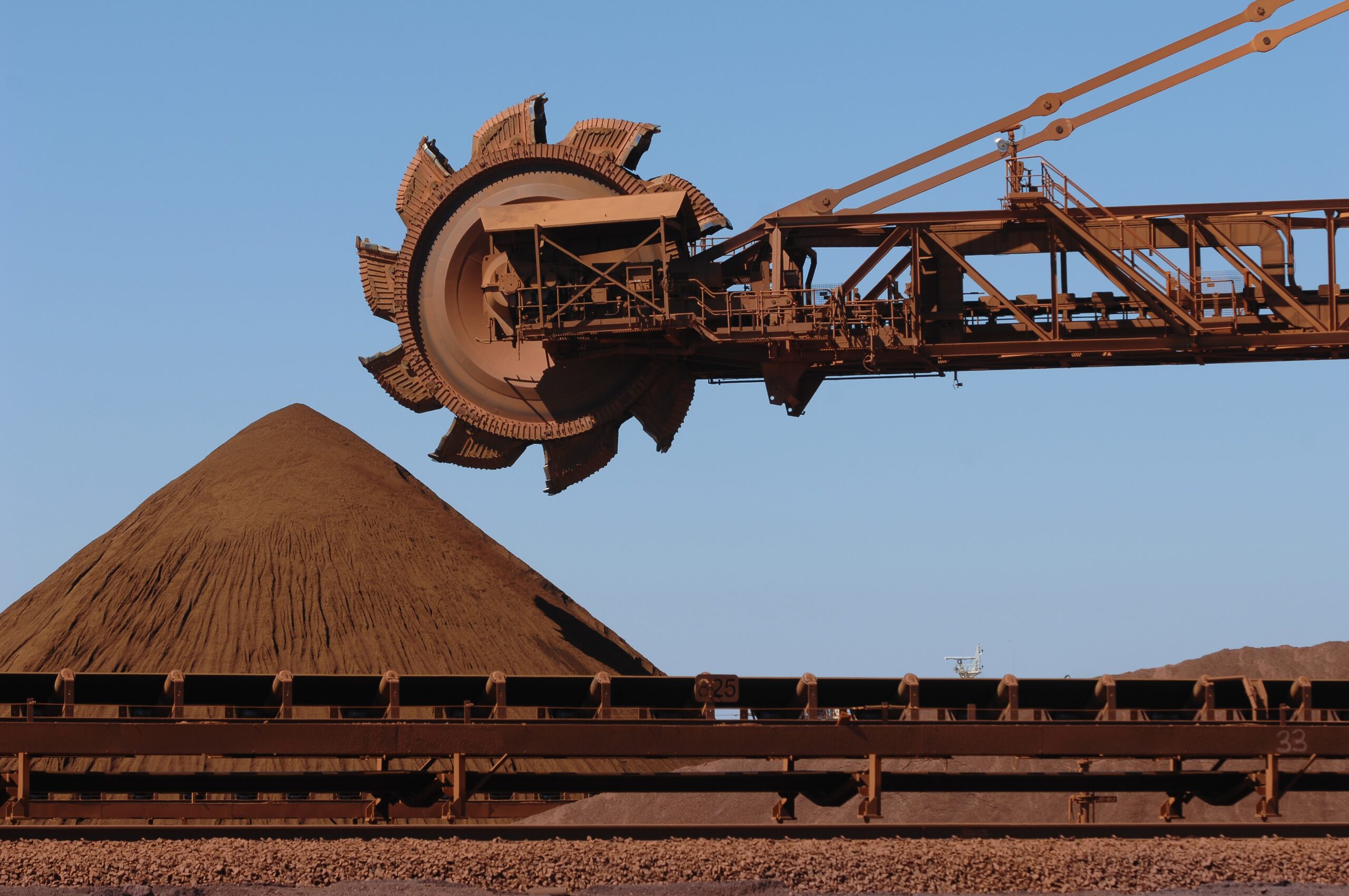 A reclaimer moving stockpiles of crushed iron ore on a mine site.