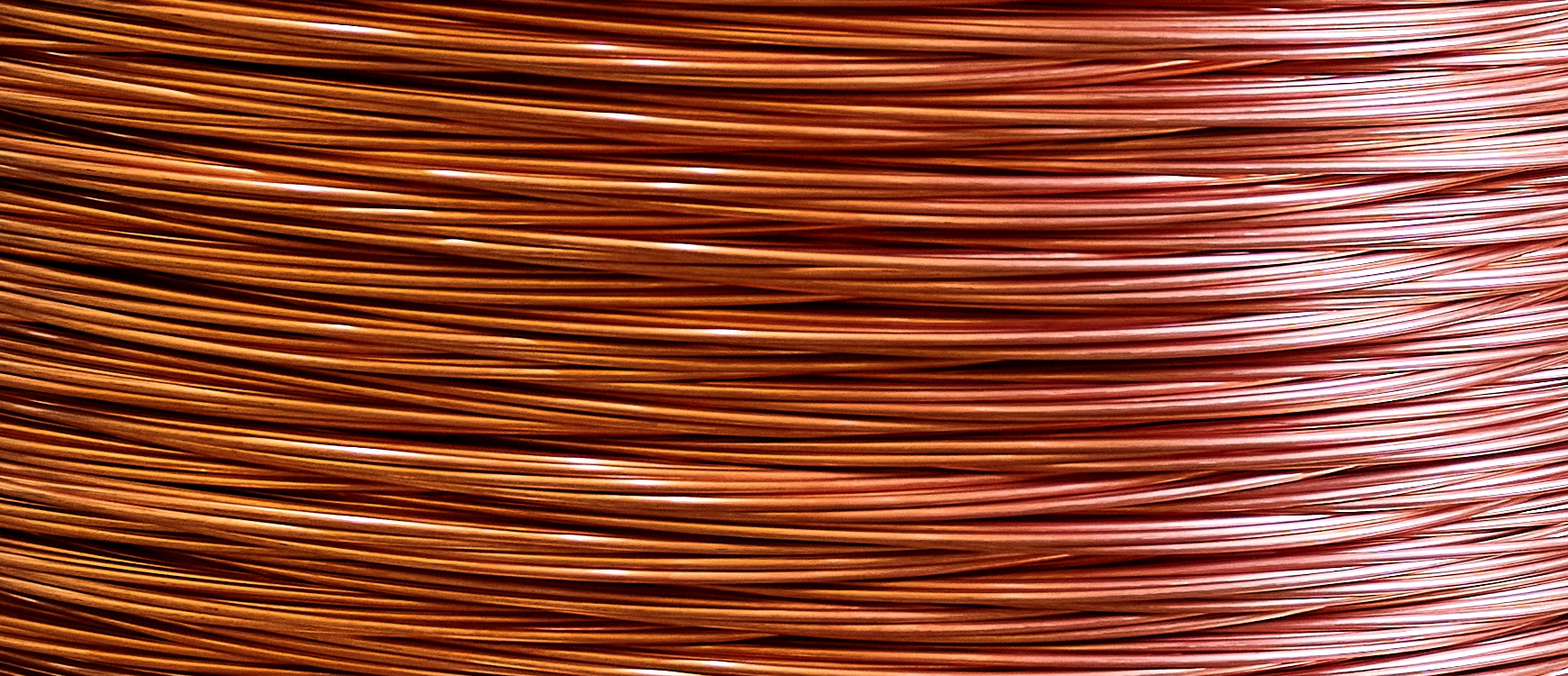 large bobbin of orange copper wire in light warehouse